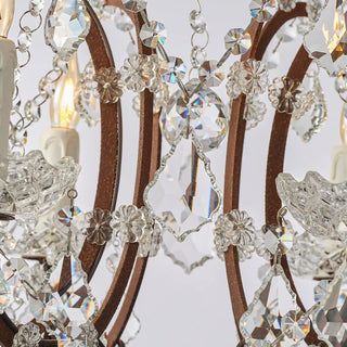 Moorizon Rustline 6-light crystal chandelier with curved iron arms and hanging crystal accents, light on with white background detail view
