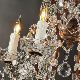 Warmly lit Moorizon Rustline crystal table lamp close-up with candle-style bulbs, faceted crystal drops, and antique-style metal accents on a dark background