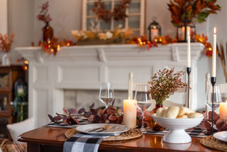 Thanksgiving dining table scene with candles, autumn leaves and glassware — warm seasonal homepage hero for Moorizon
