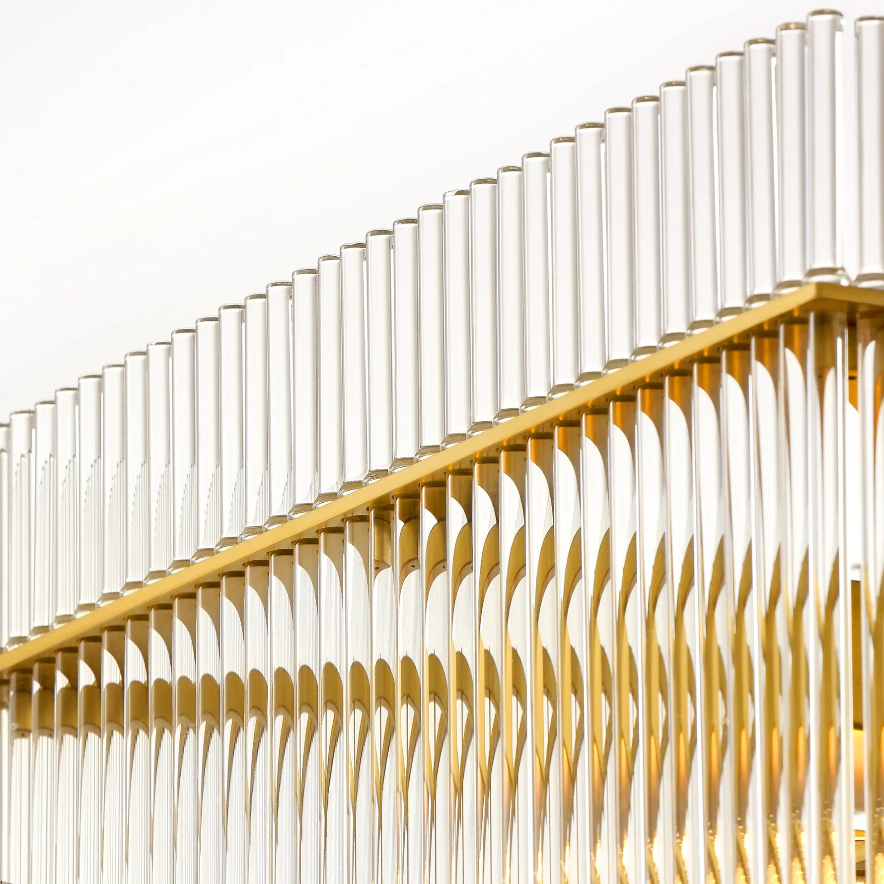 Close-up of the Timelore Rectangular Chandelier showing individual glass rods aligned beneath a warm brass frame in a white background. 