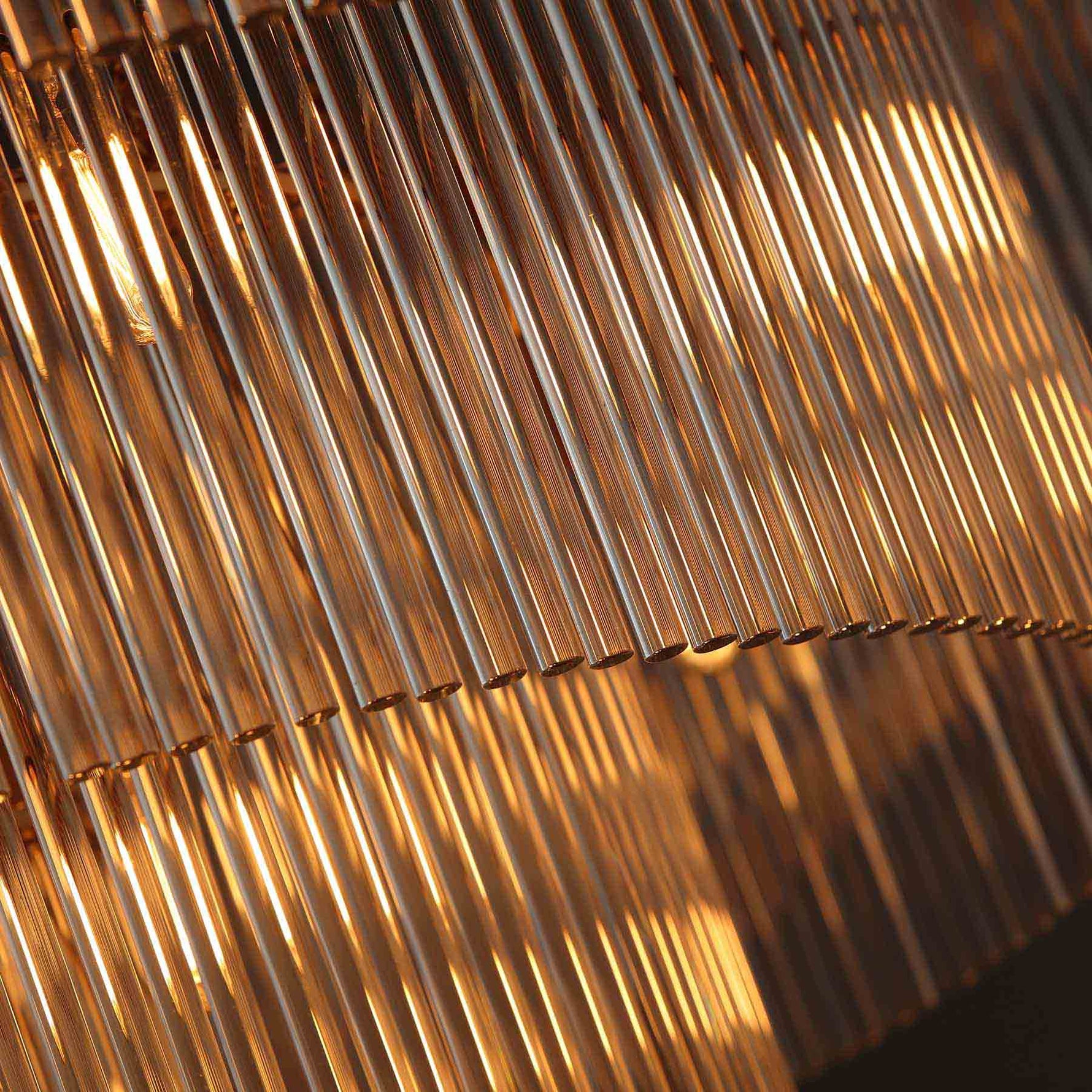 close-up of timelore chandelier showcasing finely textured crystal rods and brushed brass frame