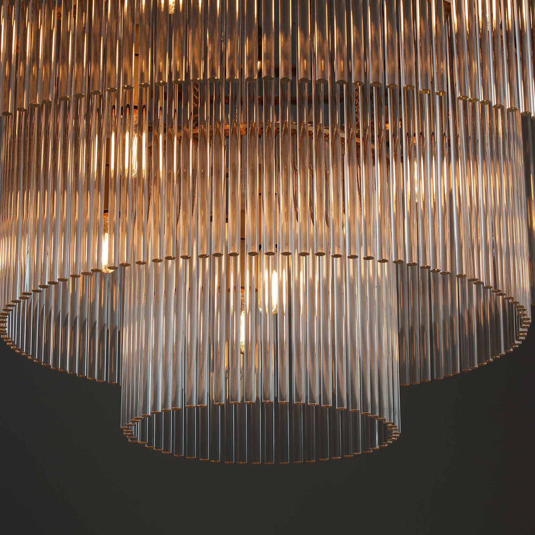 close-up of timelore tiered chandelier showcasing finely textured crystal rods and brushed brass frame
