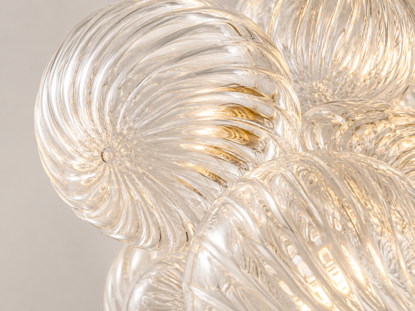 Close-up of clear spiral bubble glass highlighting sculpted ridges, organic curves, and handcrafted texture.