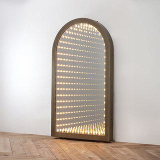 angle view of timeless gate oversized arched mirror with LED infinity lighting effect on wood floor